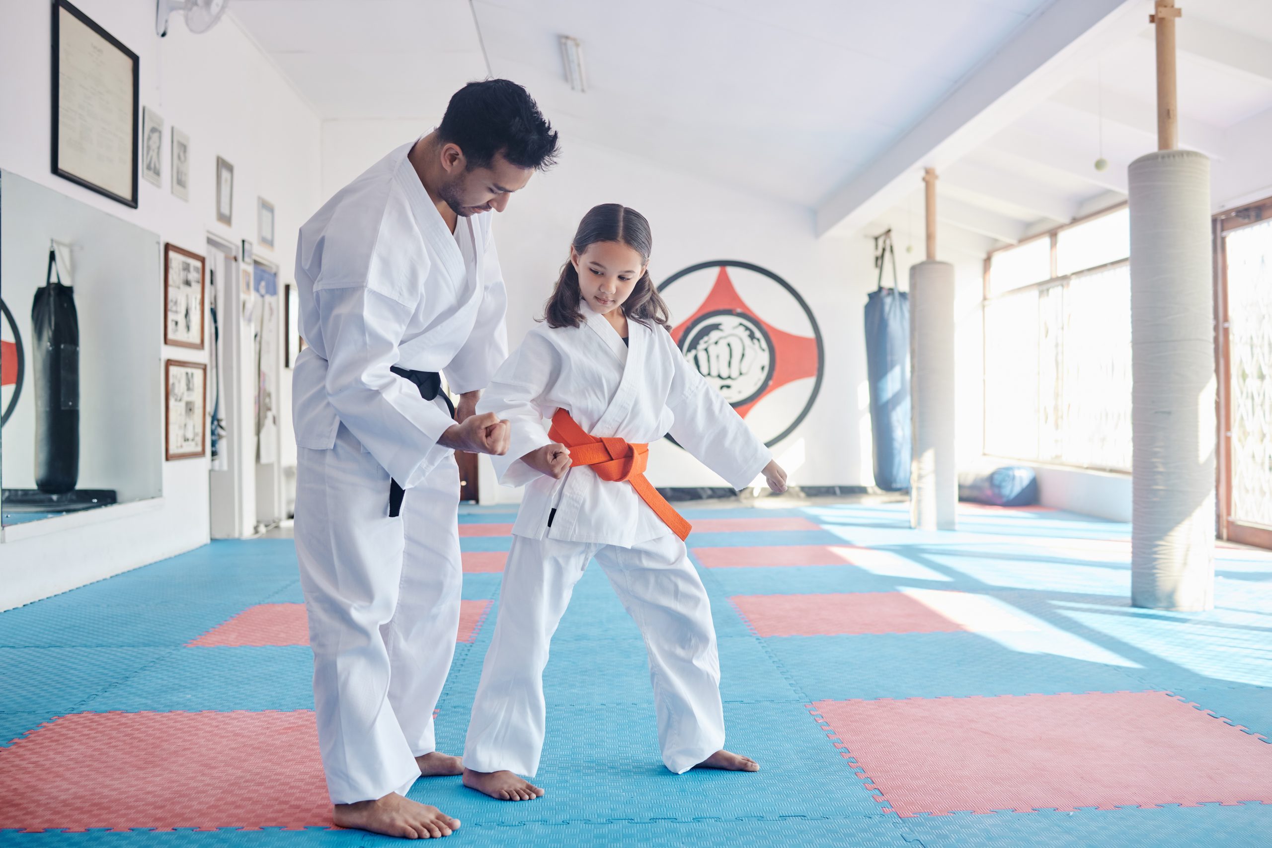Shot of a young man and cute little girl practicing karate in a studio.